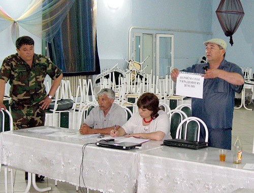 Заур  Бегендиков демонстрирует один из лозунгов Съезда ногайцев РФ, слева -начальник местной полиции Багаутдин Тангатаров. Дагестан, Ногайский район, селение Терекли-Мектеб. 28 мая 2011 г.  Фото "Кавказского узла"