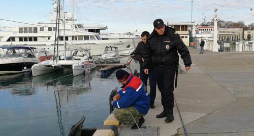 Полицейский и рыбак на причале морпорта Сочи. Фото Светланы Кравченко для "Кавказского узла".