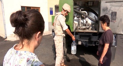 Военнослужащий МС раздает воду жителям Нагорного Карабаха. Фото пресс-службы МО России https://mil.ru/russian_peacekeeping_forces/news/more.htm?id=12378097@egNews