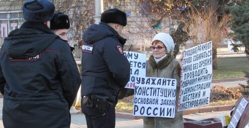 Полицейские читают плакаты Галины Тихенко. Волгоград, 12 декабря 2022 года. Фото Вячеслава Ященко для "Кавказского узла".